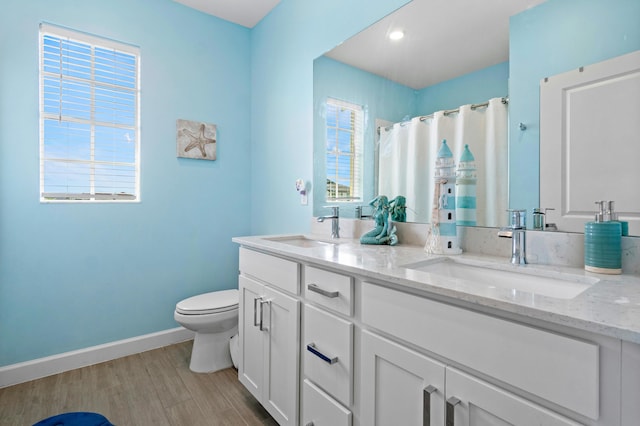 bathroom featuring vanity, toilet, curtained shower, and hardwood / wood-style floors