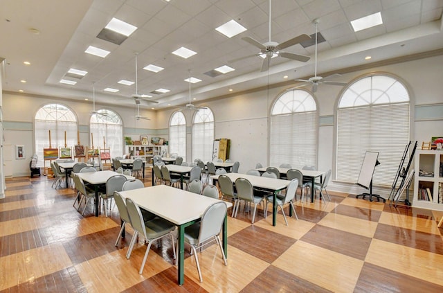 dining room with a towering ceiling and light wood finished floors