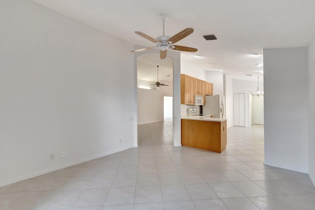 kitchen featuring ceiling fan with notable chandelier, light tile patterned floors, range, kitchen peninsula, and fridge with ice dispenser