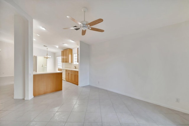 unfurnished living room featuring lofted ceiling, ceiling fan with notable chandelier, a sink, and baseboards