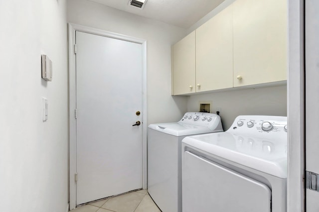 clothes washing area featuring cabinet space, light tile patterned floors, visible vents, and independent washer and dryer