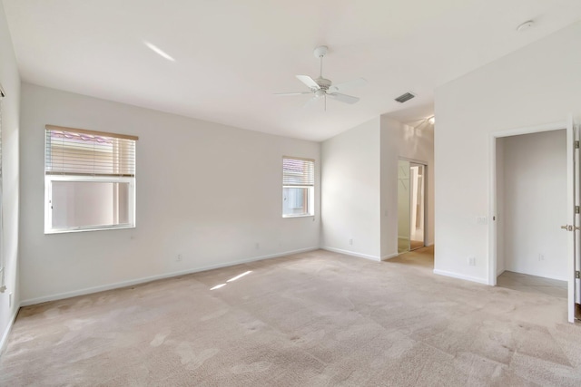 spare room with vaulted ceiling, light colored carpet, and ceiling fan