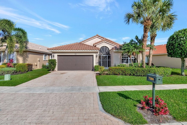 view of front of property featuring decorative driveway, an attached garage, a front yard, and stucco siding