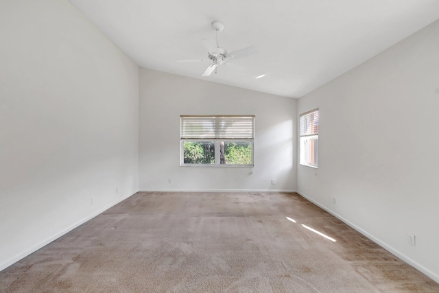 spare room featuring lofted ceiling, light colored carpet, and ceiling fan