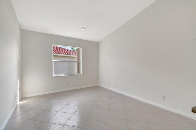 empty room featuring light tile patterned flooring and baseboards