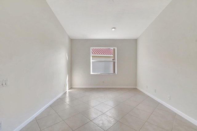 spare room with baseboards and light tile patterned floors