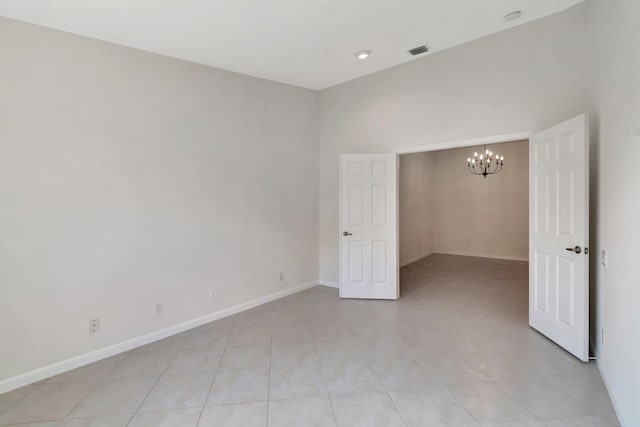 empty room featuring baseboards, visible vents, and an inviting chandelier