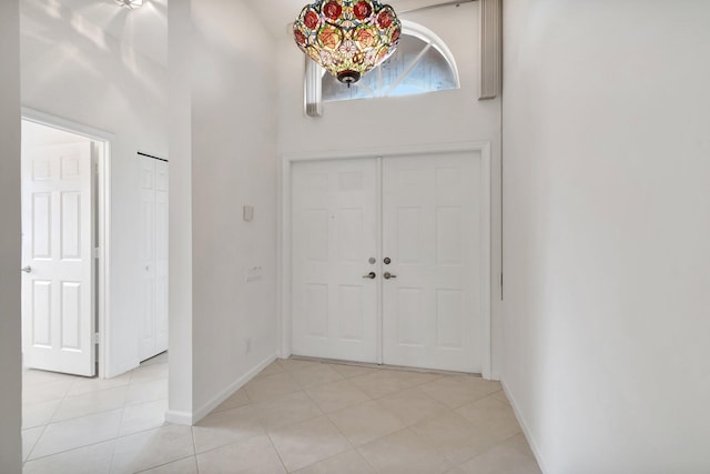 foyer featuring light tile patterned floors and a high ceiling