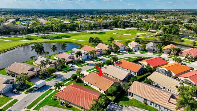 drone / aerial view with golf course view, a water view, and a residential view