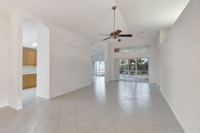 unfurnished room featuring high vaulted ceiling, baseboards, arched walkways, and a ceiling fan