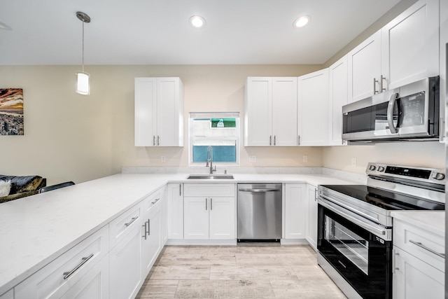 kitchen featuring white cabinetry, appliances with stainless steel finishes, sink, and pendant lighting