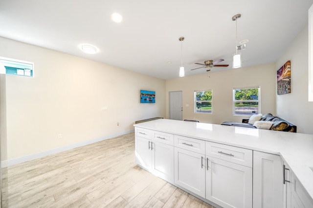 kitchen with ceiling fan, light hardwood / wood-style flooring, hanging light fixtures, and white cabinets