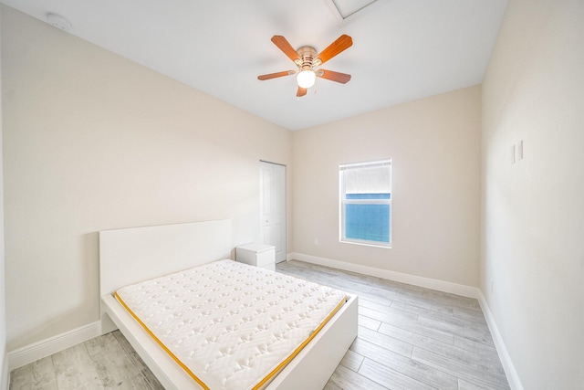 bedroom featuring ceiling fan, light wood-type flooring, and a closet