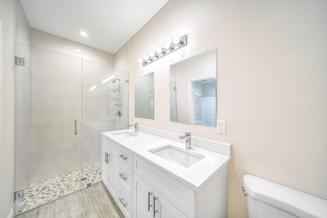 bathroom with wood-type flooring, toilet, an enclosed shower, and vanity