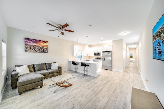 living room with ceiling fan and light hardwood / wood-style floors