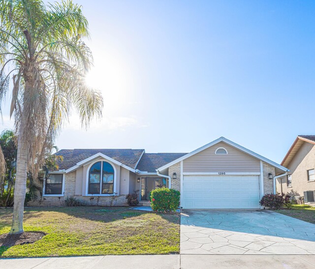 ranch-style home with a garage and a front yard