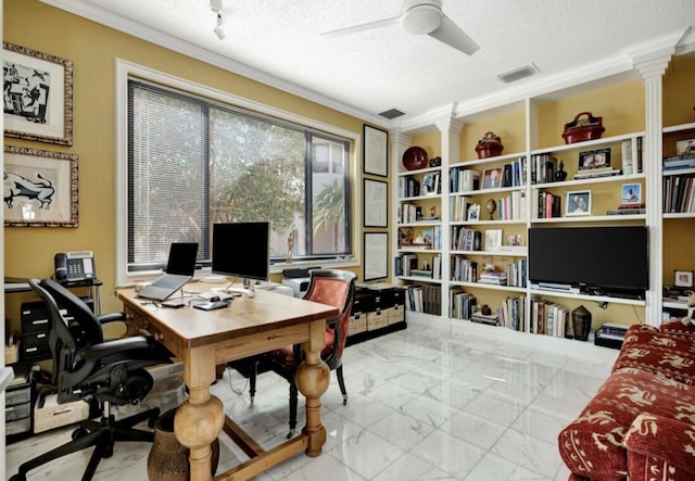 office area featuring ceiling fan, ornamental molding, decorative columns, and a textured ceiling