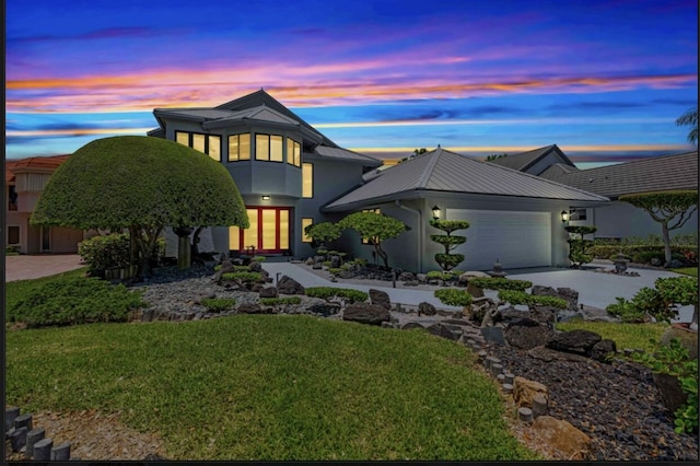 view of front facade featuring a garage and a lawn