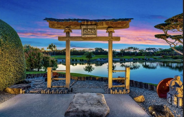 patio terrace at dusk featuring a water view