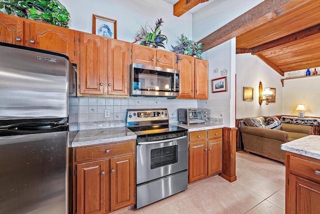 kitchen featuring light tile patterned floors, appliances with stainless steel finishes, lofted ceiling with beams, light stone countertops, and decorative backsplash