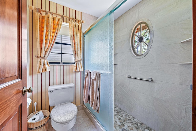 bathroom with tile patterned flooring, a shower with shower door, and toilet