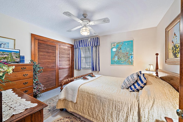 bedroom featuring ceiling fan and a textured ceiling