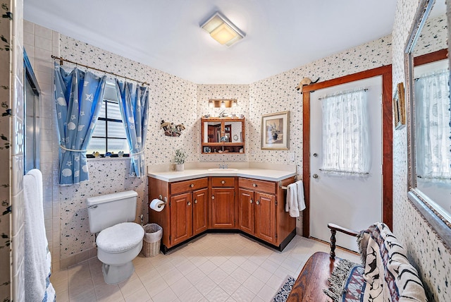 bathroom featuring tile patterned flooring, vanity, walk in shower, and toilet