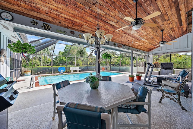 view of patio featuring ceiling fan, a fenced in pool, and glass enclosure