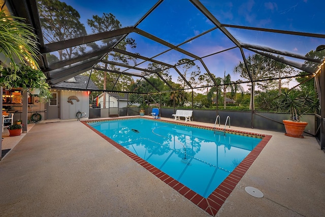 pool at dusk featuring a lanai and a patio