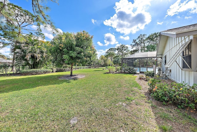 view of yard with a pool and glass enclosure