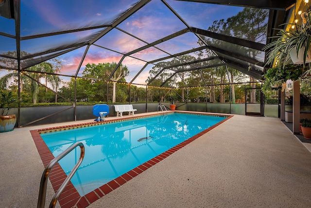 pool at dusk with a patio and glass enclosure