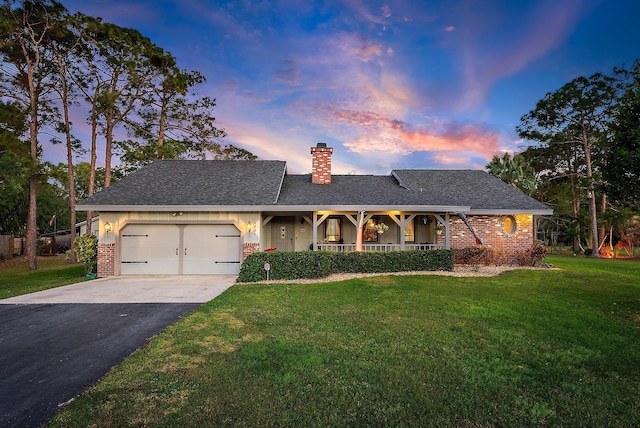 ranch-style house with a yard, covered porch, and a garage