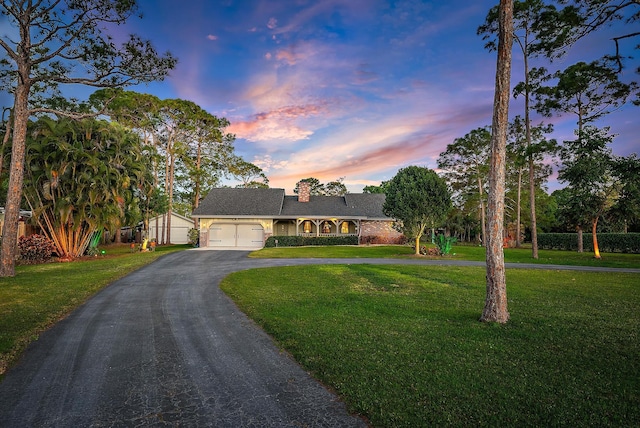 ranch-style house with a garage and a yard