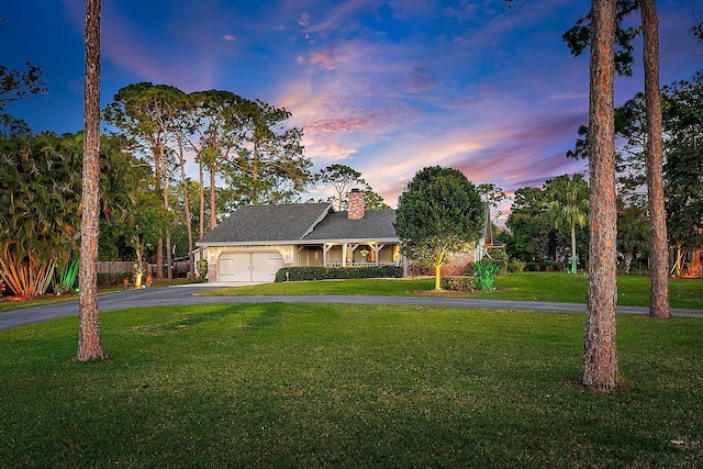 view of front of home with a garage and a yard