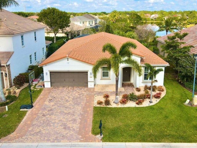 mediterranean / spanish house with a garage and a front lawn