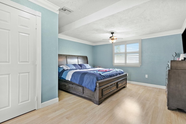 bedroom with ceiling fan, ornamental molding, light hardwood / wood-style flooring, and a textured ceiling