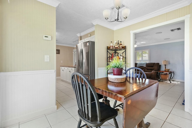 dining room with ceiling fan with notable chandelier, ornamental molding, a textured ceiling, and light tile patterned flooring