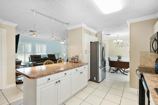 kitchen featuring light tile patterned floors, crown molding, appliances with stainless steel finishes, white cabinetry, and decorative light fixtures