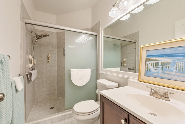 bathroom with walk in shower, vanity, and toilet