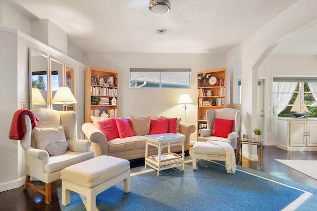 sitting room with dark wood-type flooring and a textured ceiling