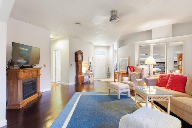 living room featuring dark hardwood / wood-style flooring and a healthy amount of sunlight