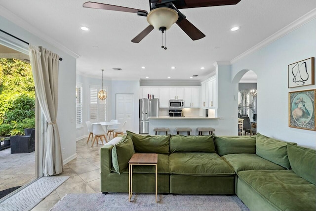 tiled living room with crown molding and ceiling fan