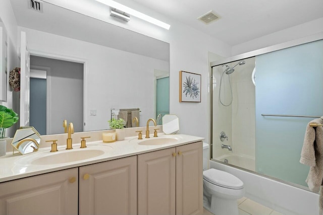 full bathroom featuring toilet, vanity, and bath / shower combo with glass door