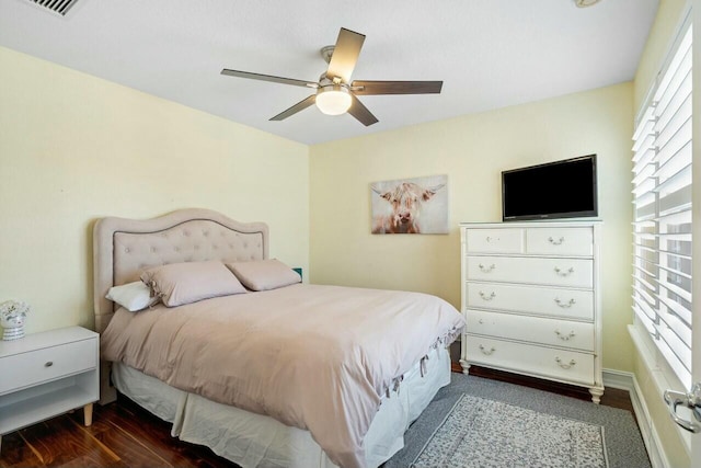 bedroom with a ceiling fan, wood finished floors, and visible vents