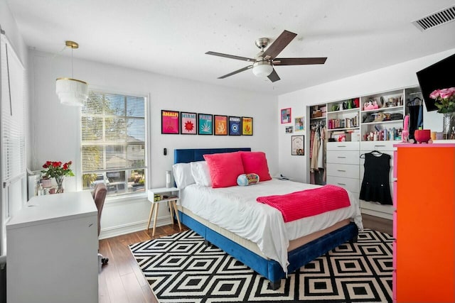 bedroom featuring visible vents, wood finished floors, a closet, baseboards, and ceiling fan