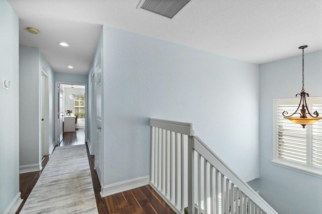 hall featuring visible vents, baseboards, an upstairs landing, recessed lighting, and wood finished floors