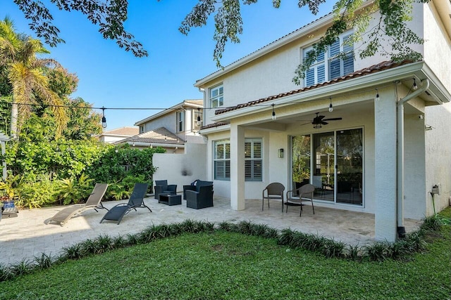 rear view of property with an outdoor living space, a patio, and ceiling fan