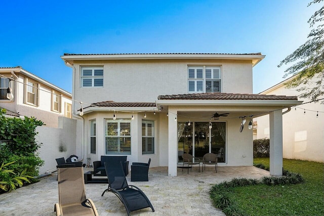 rear view of property featuring stucco siding, a tile roof, a patio, and ceiling fan