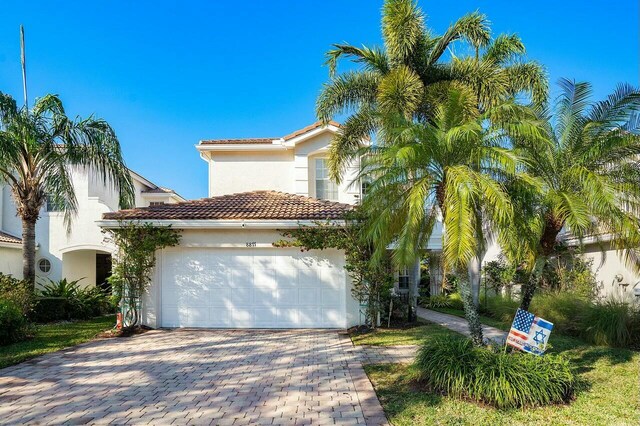 8877 Kettle Drum Ter, Boynton Beach, FL 33473 - view of front facade with stucco siding, a tile roof, a garage, and decorative driveway