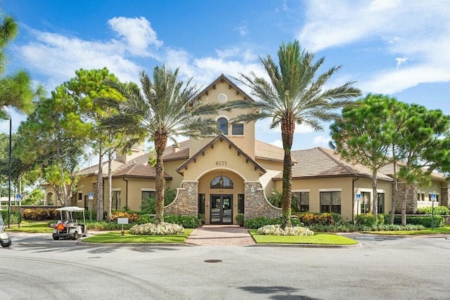 view of front facade featuring stucco siding, stone siding, and french doors